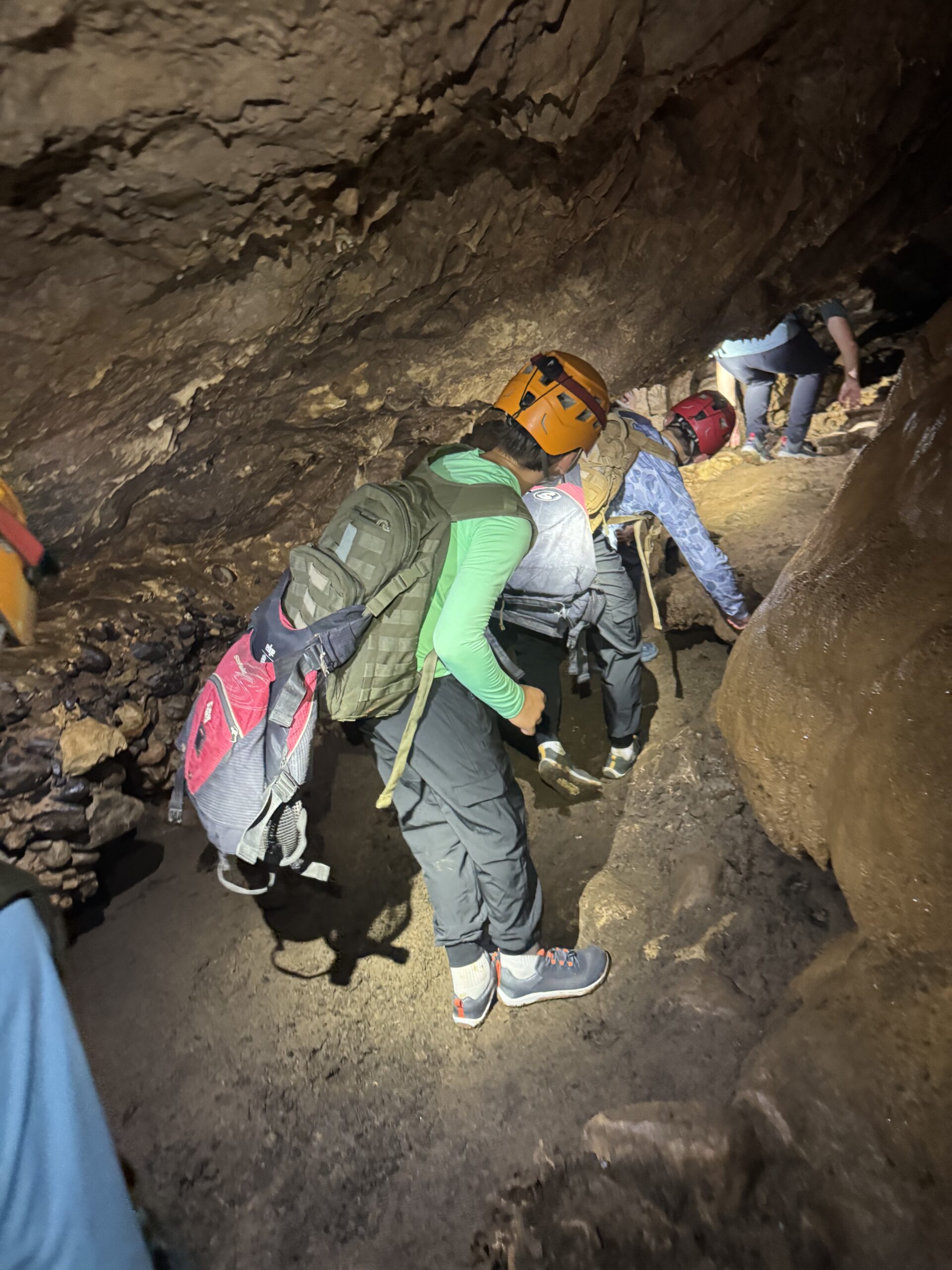 Family hiking through Caves Branch cave system to waterfalls
